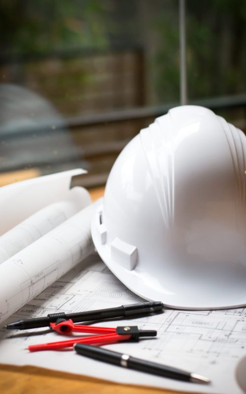 construction concept image helmet rolled blueprints on wooden boards in retro style.